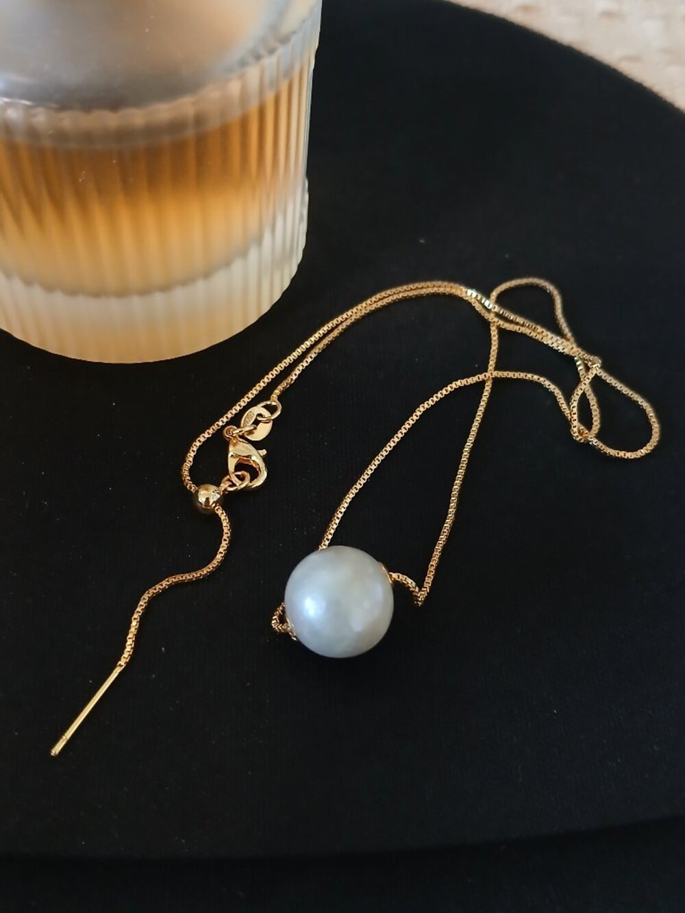 A gold chain necklace featuring pearls
